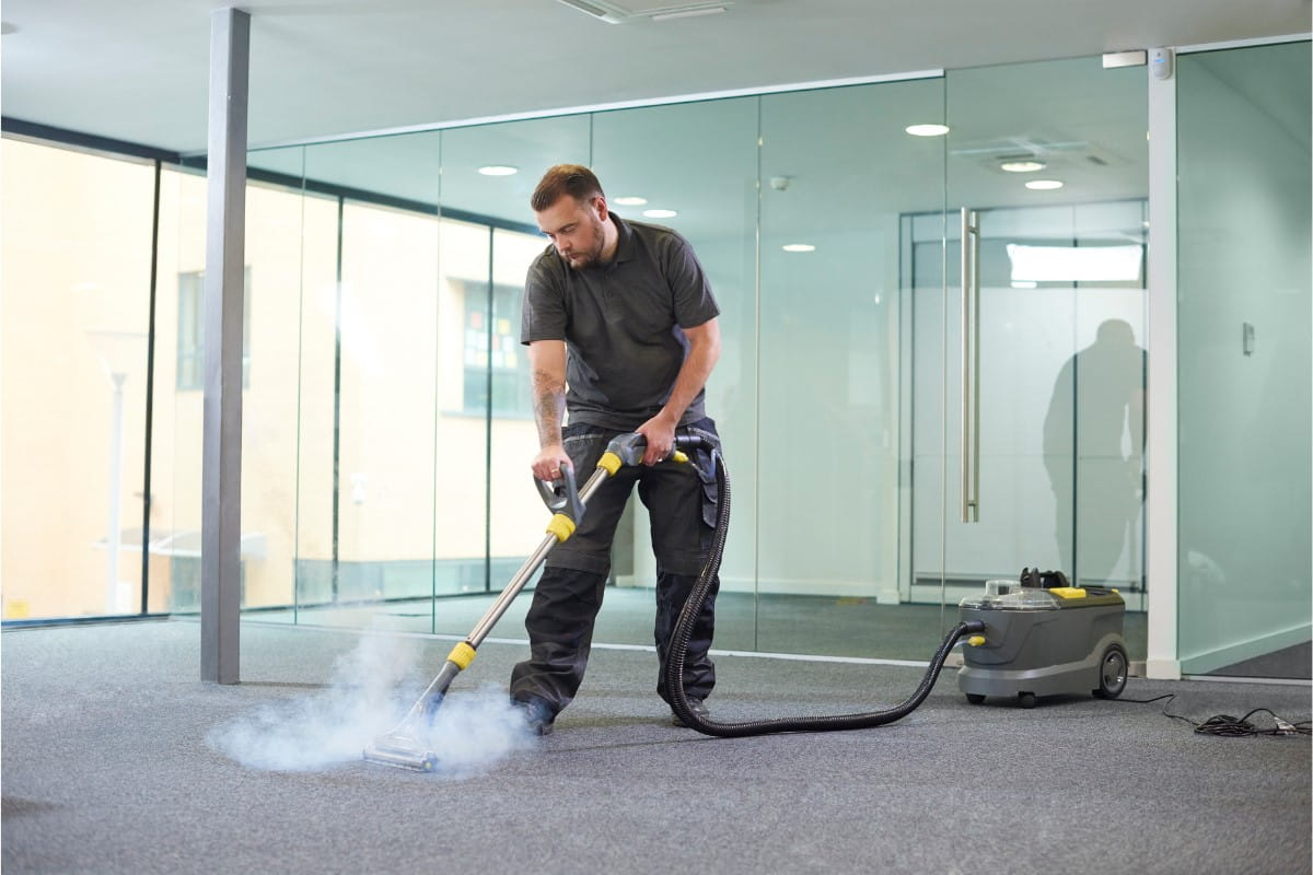 Image of a man deep cleaning office carpeting as part of commercial carpet cleaning services