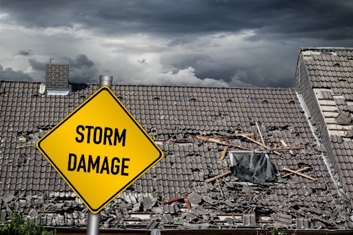 Image of a house with a storm damaged tile roof that needs emergency restoration services.